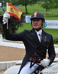Juan Manuel Munoz Diaz waves a Spanish flag on which "ANIMO JORDI" is written to support team mate Jordi Domingo who lost his number one Grand Prix horse Prestige the week before