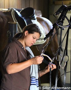 Groom Ninon Meunier taking care of the tack