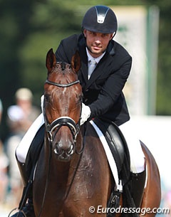 Riding for Belgium, Dutch Rob van Puijenbroek gives his Oldenburg gelding Seymour (by San Amour x Friedensfurst) a big pat. 