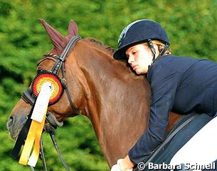 Julia de Ridder hugging Comtessa. This chestnut mare was one of Nadine Capellmann's young horses but was sent to Ton de Ridder to be sold. The mare stayed and is now his daughter Julia's ride