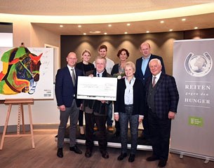 Klaus Roeser, Elisabeth Kamp, auctioneer Uwe Heckmann, Hauke Schremmer, Gudrun Bauer, Christiane Ullmann, Markus Wörmann, and Ullrich Kasselmann with the cheque for Riding Against Hunger at the 2015 PSI Auction