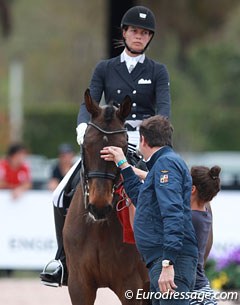 Trainer Dieter Laugks gives Sylvia Gugler's Baudolino a quick pat before they enter the ring