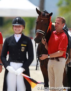 Dad Johannes Westendarp holds Der Prinz while daughter Alexa gets ready to mount the podium to receive the team gold medal