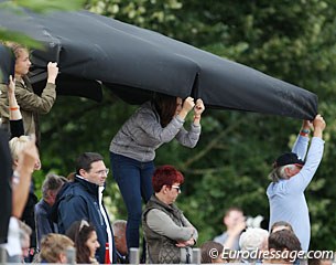 Holding down the parasol to prevent it from flapping during the test